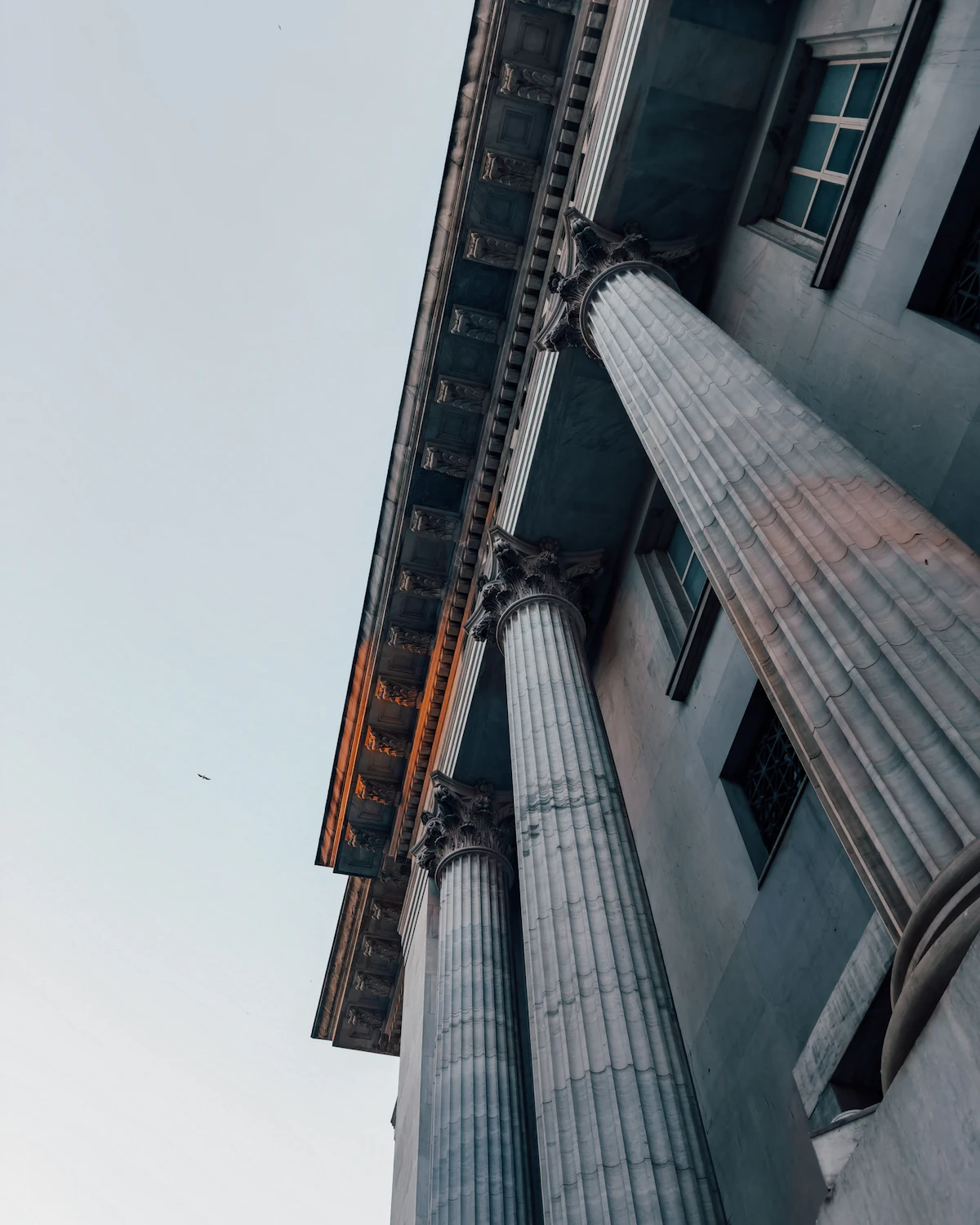 The stone columns of a bank building seen from below