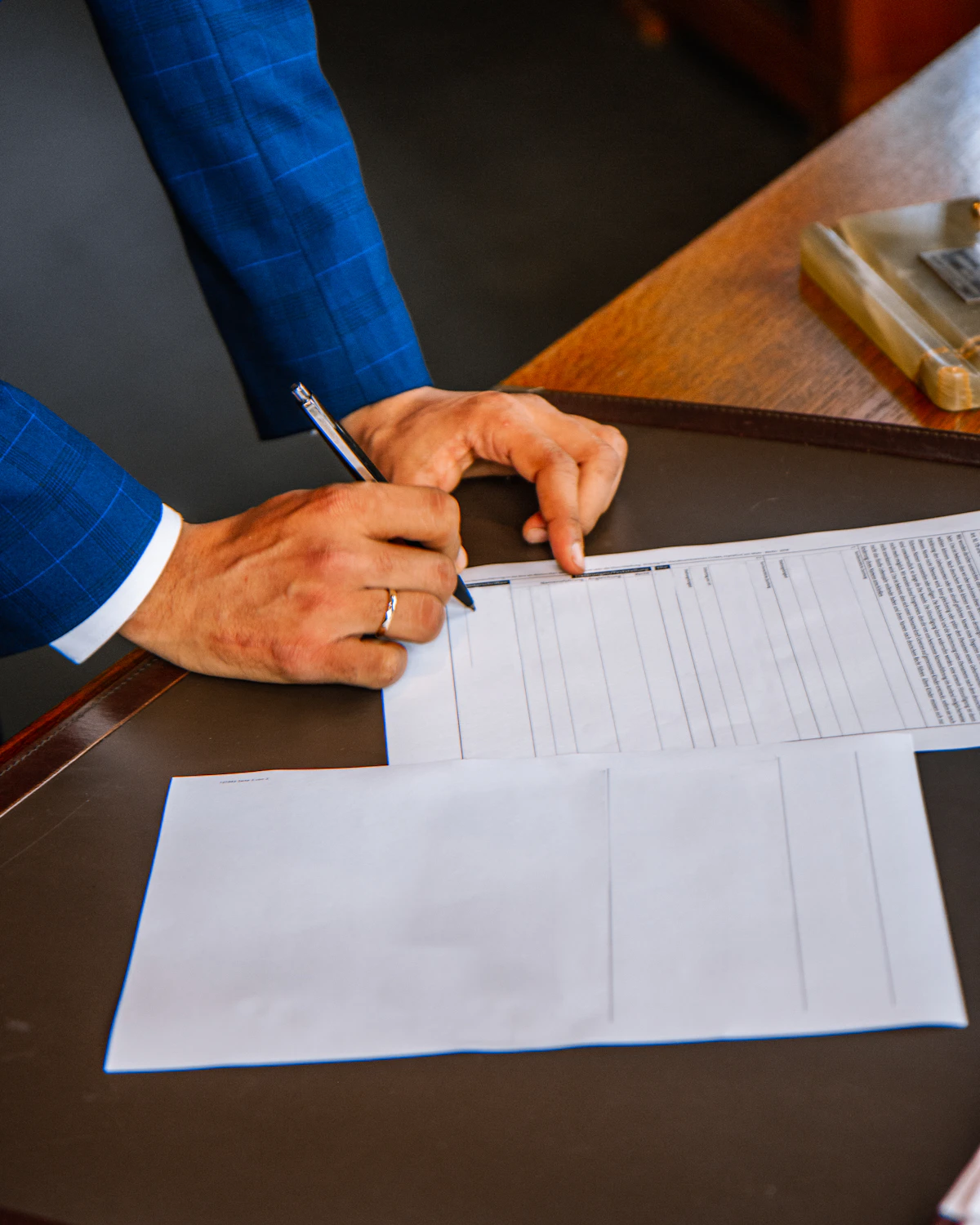 A fiduciary signing client documents at a desk